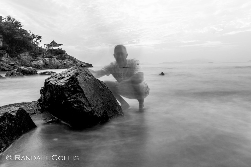 Long-exposure photograph of a ghostly figure at the shoreline