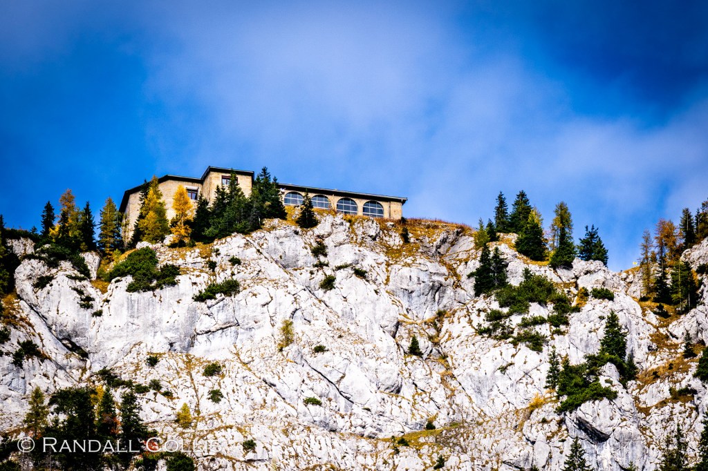 The Kehlsteinhaus perched above a limestone cliff, autumn trees below